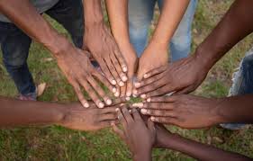 8 hands with different skin colours meeting in the middle of a circle